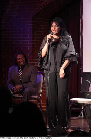 Primary view of object titled '[Man sits behind Pam Grier]'.