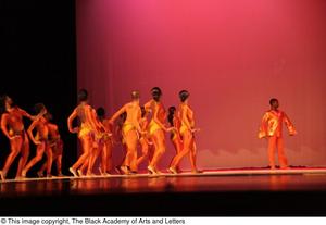 [Photograph of a group of dancers standing on a stage in orange leotards, 2]