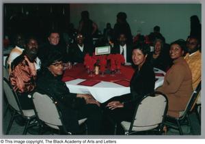 [Attendees seated at Christmas Kwanzaa soiree]