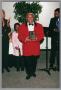 Photograph: [Woman holding up her plaque at the Christmas Kwanzaa soiree]