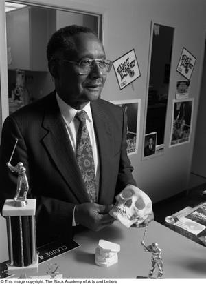 [Dr. Claude Williams photographed holding model skull, 3]