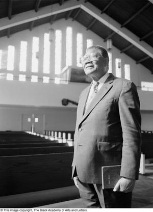 [Photograph of the Reverend Clarence Booker Taliaferro Smith standing in church sanctuary]