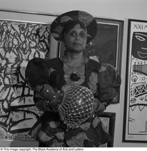 [Photograph of Dr. Njoki McElroy posing with art vase]