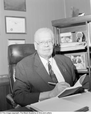 [Photograph of Fred Leonard Lander, III seated at his office desk #2]