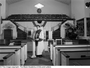 [Photograph of Dr. S. M. Wright standing in a church's nave]