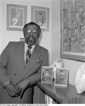 Primary view of object titled '[Abner Haynes posing with football memorabilia]'.