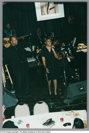 [Photograph of Sandra Kaye and a band performing on stage]