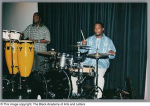 Primary view of object titled '[Photograph of two men playing their respective drums on stage]'.