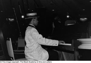 [Photograph of an unidentified man playing the piano]
