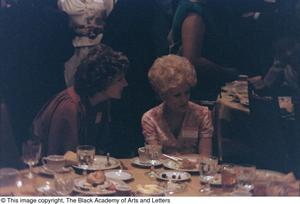 [Photograph of two women, wearing name tags]