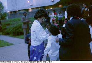 [Photograph of woman receiving rose from young child]