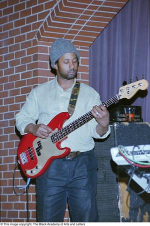 [Unknown bass guitar player performing with reggae band]