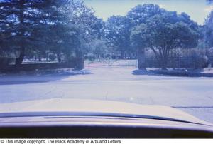 [Photograph of a gate taken from the inside of a vehicle]