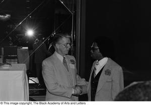 [Photograph of Jack Evans shaking hands with an unidentified man]