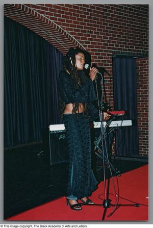 Primary view of object titled '[Photograph of artist Rhea singing into microphone]'.