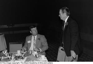 [Photograph of two men at their dining table]
