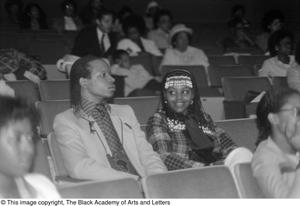 [Photograph of couple seated in auditorium]