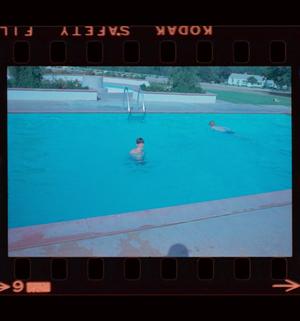 [Photograph of two boys swimming in a pool]