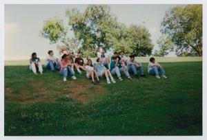 [Photograph of TAMS students sitting on field]