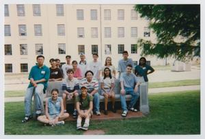 [Photograph of TAMS students posing with a memorial bench]