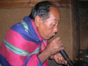 Thamthi Tholung blowing a pipe to light the fire
