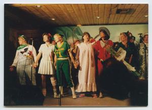 [Photograph of Peter Pan cast members singing on stage]
