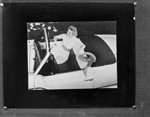 [Woman sitting inside an automobile]