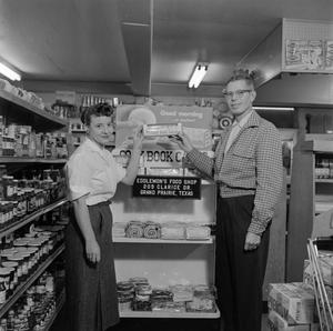 [Man and woman in front of display at Eddlemon's Food Shop]