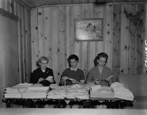 [Three women opening letters]