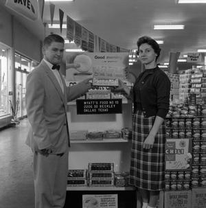 [Man and woman standing in front of Cook Book Cakes display 2 of 2]