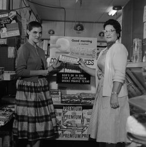 [Two women standing in front of Cook Book Cakes display 2 of 2]