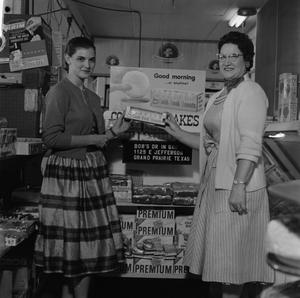 [Two women standing in front of Cook Book Cakes display 1 of 2]