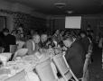 Photograph: [Roy Bacus and group at long table]