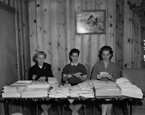 [Women opening letters from a pile]