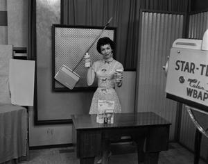 [Freda Holt holding up Bissell products]
