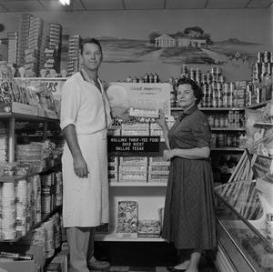 [Man and woman standing in front of store display]