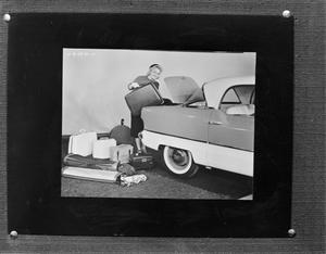 [Woman putting luggage in a trunk]