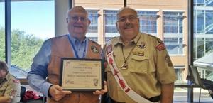 [John Anderson holding University of Scouting certificate]
