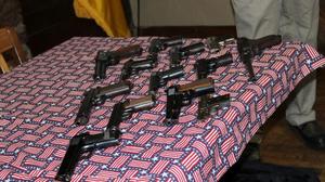 Primary view of object titled '[Handguns displayed on flag tablecloth, January 13, 2018]'.