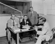 Photograph: [Photo of men in studio signing contract]