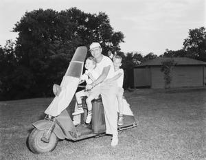 [Man with young boys on a scooter at WBAP picnic]