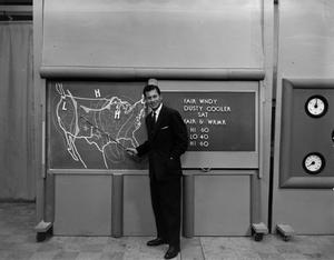 Primary view of object titled '[Larry Morrell and weather board]'.