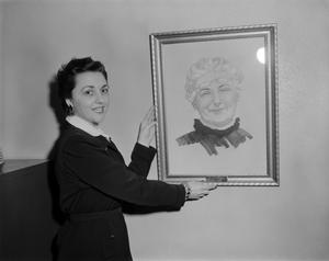 [Margaret McDonald holding a Mrs. Tucker portrait drawing]