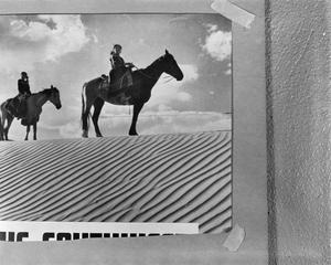 [Slide of two people on horses]
