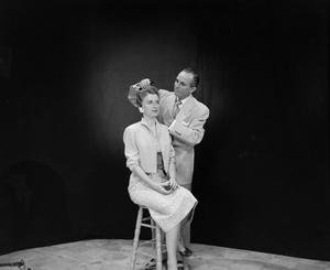 [Photo of Vernon Isbell fixing a model's hair]
