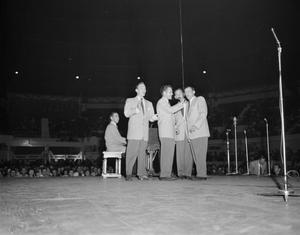 [Photograph of four men performing]
