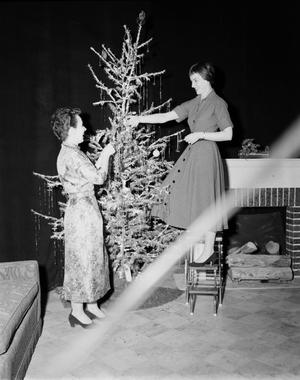 [Photograph of Ann Alden with guest and Christmas tree]