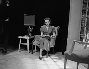 [Photo of a woman sitting in a chair]