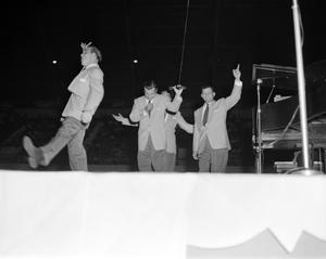 [Photograph of four men performing on stage]