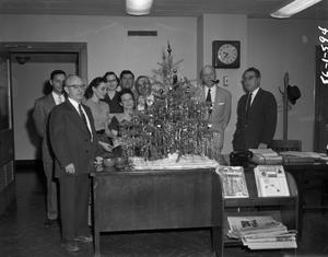 [Photograph of people around a Christmas tree]